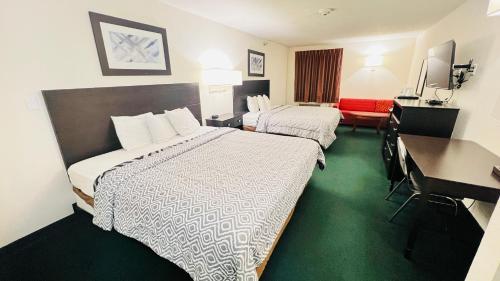 Habitación de hotel con 2 camas y escritorio en Americas Best Value Inn Pinckneyville, en Pinckneyville