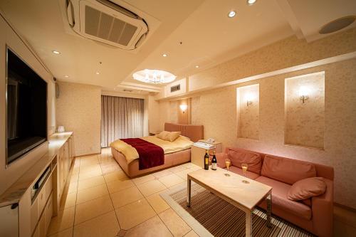 a hotel room with a bed and a couch at sala del rey Kyoto South in Kami-tobachō