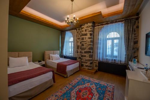 a bedroom with two beds and a sink and windows at Ve Hotels Beylerbeyi Sarayı in Kars