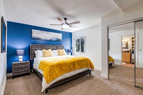 a blue bedroom with a bed and a ceiling fan at The Kozi Sandbox in Oceanside