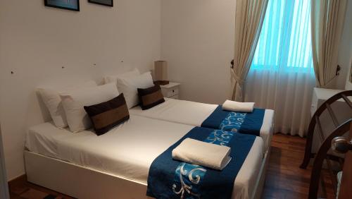 Beach Paradise Nilaveli في ترينكومالي: غرفة نوم بسرير أبيض مع بطانية زرقاء