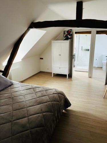 a bedroom with a bed and a room with a attic at Le gite de l’oppidum in Étrun