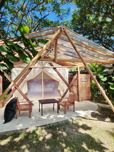 a wooden tent with two chairs and a bench at ลูกช้างเขาใหญ่แคมป์ in Ban Tha Maprang