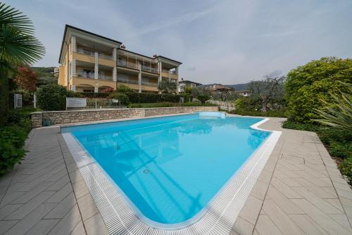 a swimming pool in front of a house at Appartamento Amaryllis, incantevole con piscina in Salò