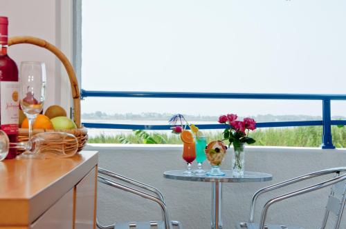 een tafel met twee glazen en een mand met fruit en bloemen bij Hotel Tigaki's Star in Tigaki