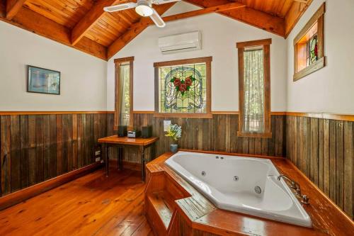 een grote badkamer met een bad en een glas-in-loodraam bij StayAU The Loft 1BR Rustic Picturesque Cottage in Badger Creek