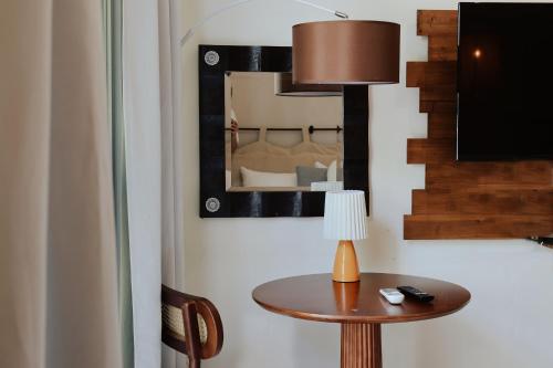 a table with a lamp and a mirror on a wall at 沉靛旅宿 La Casa Indaco 墾丁夢幻島Villa in Sigou