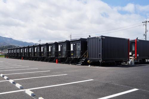 a row of train cars parked in a parking lot at HOTEL R9 The Yard Konan in Konan