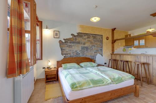 a bedroom with a bed and a stone wall at Tourist Farm Tonin - Apartments - Happy Rentals in Šmarje