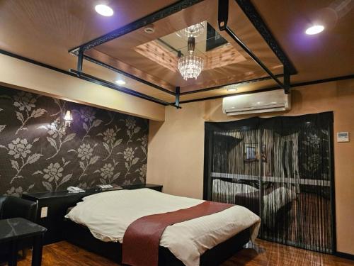 a bedroom with a bed and a chandelier at 夢街道53 in Okayama