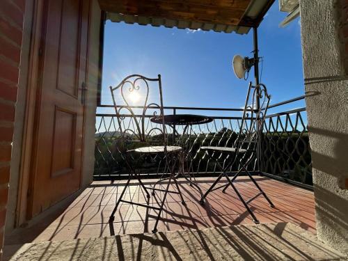 una mesa y sillas en un balcón con ventana en Aura Entis, en Canino