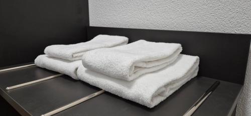 Trzy ręczniki są ułożone na półce w pokoju w obiekcie Melvi Hotel Göppingen w mieście Göppingen