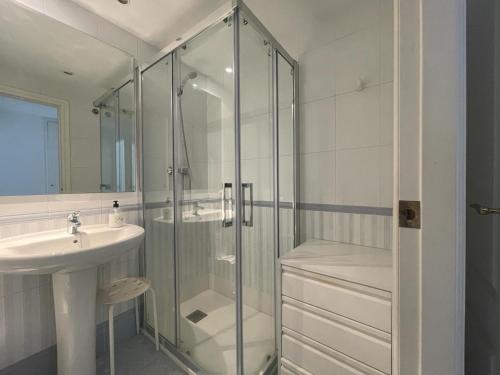 uma casa de banho com uma cabina de duche em vidro e um lavatório. em Spacious & bright apartment em Aduanas