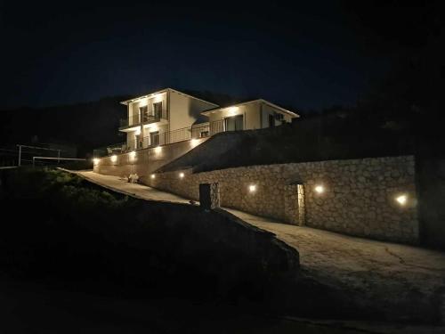 a building with lights on a wall at night at Anemar Lefkada in Drymon