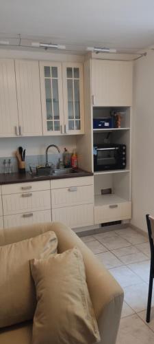 un salon avec un canapé et une cuisine dans l'établissement Studio centre ville de Narbonne, à Narbonne