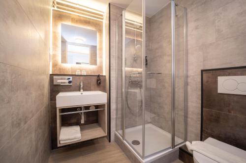 een badkamer met een douche en een wastafel bij Fletcher Hotel Restaurant Rooland in Arcen