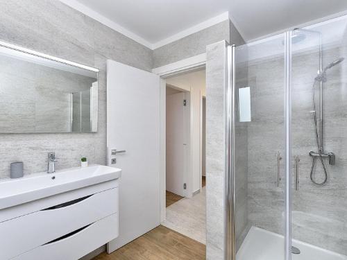 a bathroom with a white sink and a shower at Modern villa with private hydromassage pool in Vodnjan