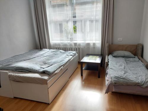 a bedroom with two beds and a window at Bright spacious apartment with street parking in Rīga