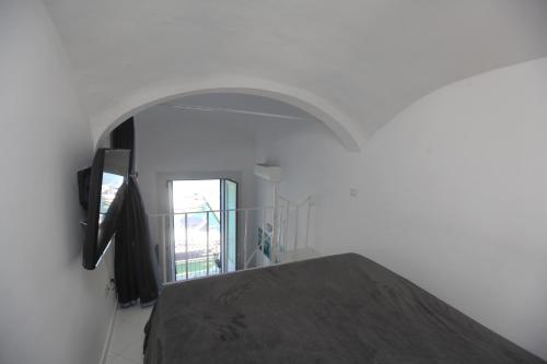 een witte kamer met een bed en een raam bij Rd Guest house in Ischia