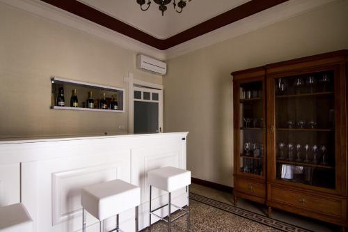 a bar with two white stools and a fireplace at Dimora De Mauro in Catania
