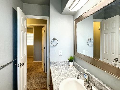 a bathroom with a sink and a mirror at Stunning 3br Oasis Rainshower Family Fun in Oklahoma City