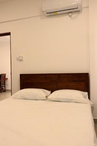 a bed with two white pillows and ailver at Colombo City Apartment in Colombo