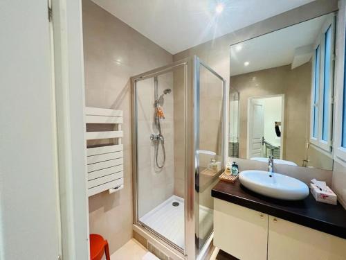 a bathroom with a sink and a glass shower at Suffren Studio in Paris