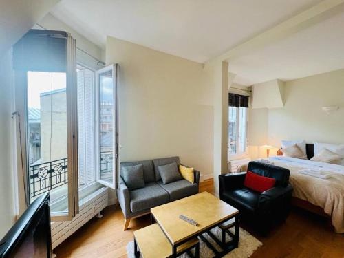 um quarto com uma cama, um sofá e uma cadeira em Suffren Studio em Paris