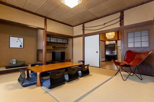 a large room with a wooden table and chairs at 【Oyado龍】檜の露天風呂付 和モダンな古民家115㎡貸し切りの宿 1日1組限定【8名宿泊可能】 in Asahimachi