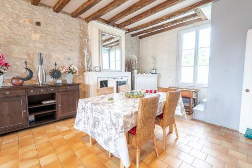 a dining room with a table with chairs and a fireplace at La Maison du Bonheur - Francueil in Francueil