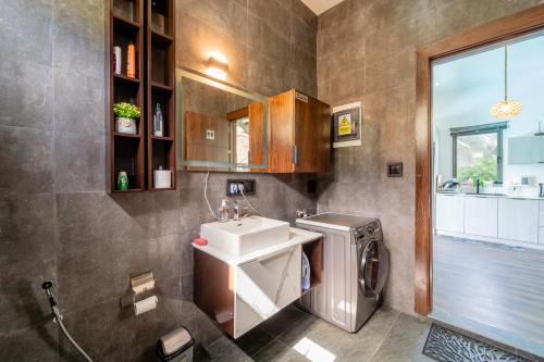 a bathroom with a sink and a washing machine at Keenoo Villa - An elegant villa in a calm area in Pamplemousses Village