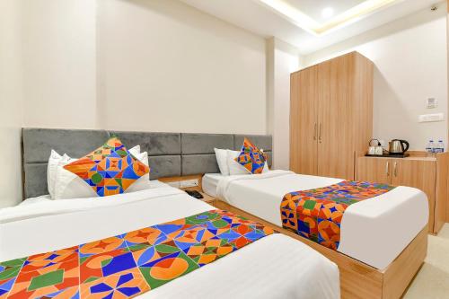 a hotel room with two beds with colorful pillows at FabHotel Prime Rudura Palace in Udaipur
