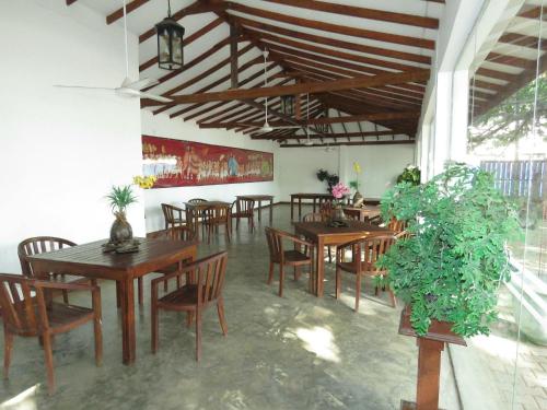 a dining room with wooden tables and chairs at Trinco Rest House in Trincomalee