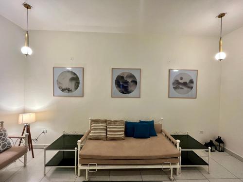 a couch in a room with paintings on the wall at AruBhi Cottage in Dehradun