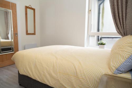a bed in a room with a window at Unit 1 Island View Apartments - Town Centre Walk To Everything in Cobh
