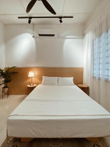 1 dormitorio con 1 cama blanca grande en una habitación en Hinggap Cendana en Masai