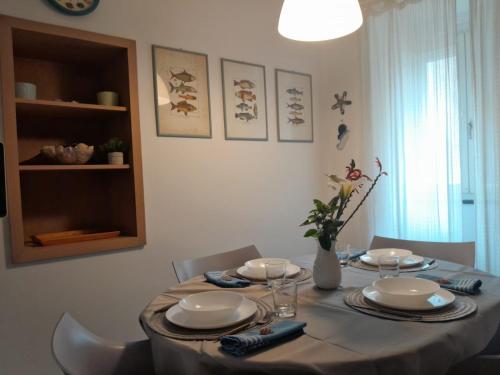 a dining room table with plates and a vase on it at Capraia per te in Capraia