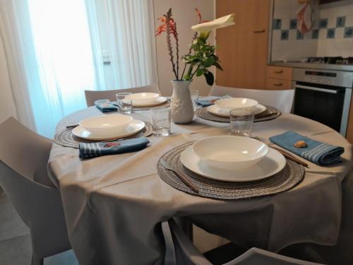 a table with a white table cloth and plates and glasses at Capraia per te in Capraia