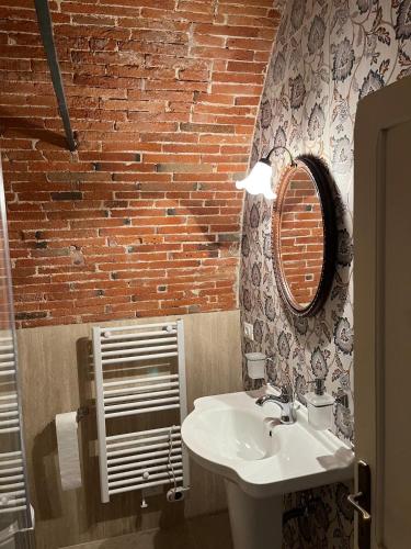a bathroom with a sink and a brick wall at Hotel Villa Sermolli in Borgo a Buggiano