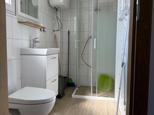 a bathroom with a toilet and a glass shower at A cozy house near the sea, azy in Łazy