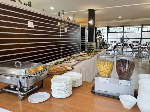 una línea de buffet con platos y comida en un restaurante en A cozy house near the sea, azy en Łazy