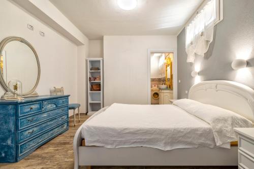1 dormitorio con cama blanca y cómoda azul en Domo Minore, en Palmadula
