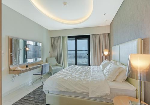 a bedroom with a bed and a desk and a window at Savis Homes - Damac Paramount Tower A 1BR Ultimate Luxury and Glam Escape in Dubai