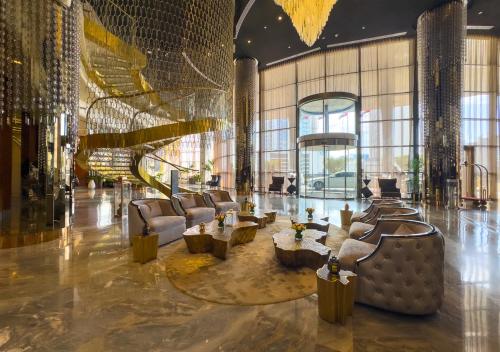 a lobby with couches and tables in a building at Savis Homes - Damac Paramount Tower A 1BR Ultimate Luxury and Glam Escape in Dubai