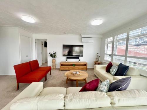 a living room with a white couch and a tv at Wharf Boutique Apartments in Gold Coast