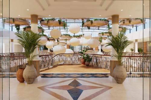 a lobby with potted plants and chandeliers at AluaSoul Costa Adeje in Adeje