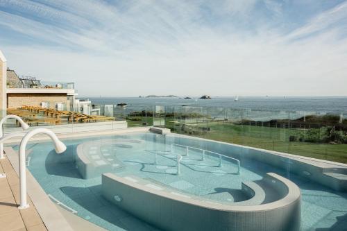 a swimming pool with a view of the ocean at Emeria Dinard Thalasso Spa - Avril 2024 Réouverture après rénovation in Dinard