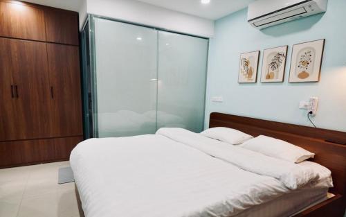 a bedroom with a bed and a glass shower at Niah Cozy Home - Train Street in Hanoi