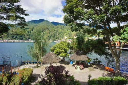 a view of a beach with umbrellas and the water at Pandu Lakeside Hotel Parapat in Parapat