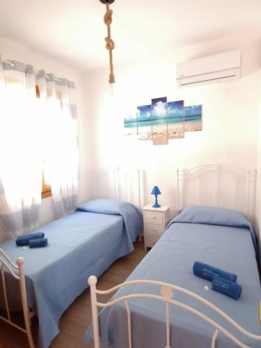 two beds in a room with white walls at Villa Mykonos in Fontane Bianche